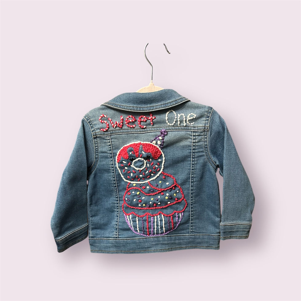 Denim jacket featuring a festive donut and cupcake embroidery with "Sweet One" stitched above, perfect for a playful and charming look.