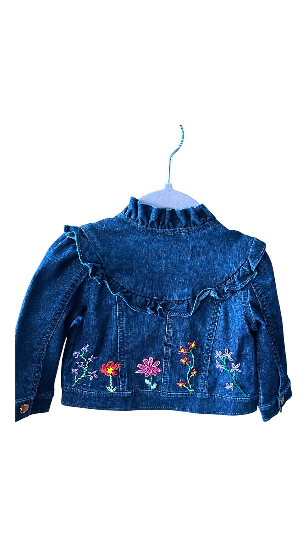 A charming denim jacket adorned with colorful floral embroidery and ruffled accents