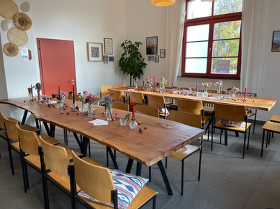 Festlich gedeckte Holztische im Eventraum