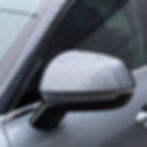 Gray car side mirror with water droplets