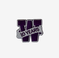 Embroidered mini patch with a purple and white design, showcasing the letter "W" and "10 years" to celebrate a team milestone.