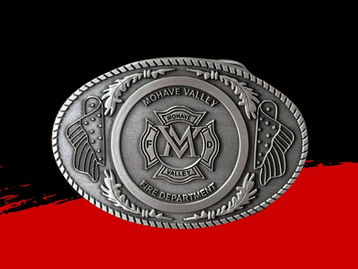 An oval, antique silver belt buckle featuring a stylized flag, decorative elements, and a Maltese cross in the center.
