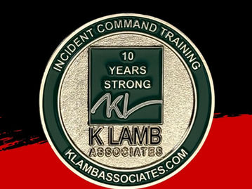 Silver textured corporate coin with embossed text, displayed on a solid black background.