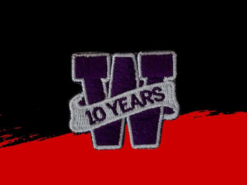 A small, deep purple, embroidered patch with contrasting grey details.