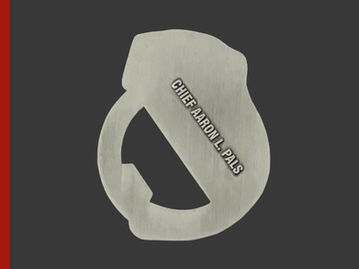 Manly Police cuff-shaped antique silver challenge coin bottle opener with police chief's name.