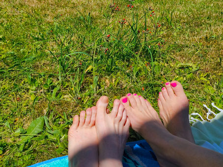 Nadine und Katerina sitzen barfuß auf einer Decke im sonnigen Garten – entspannt, geerdet und verbunden. Der Startschuss für ein tiefes Gespräch über den Körper als Schlüssel zu uns selbst.