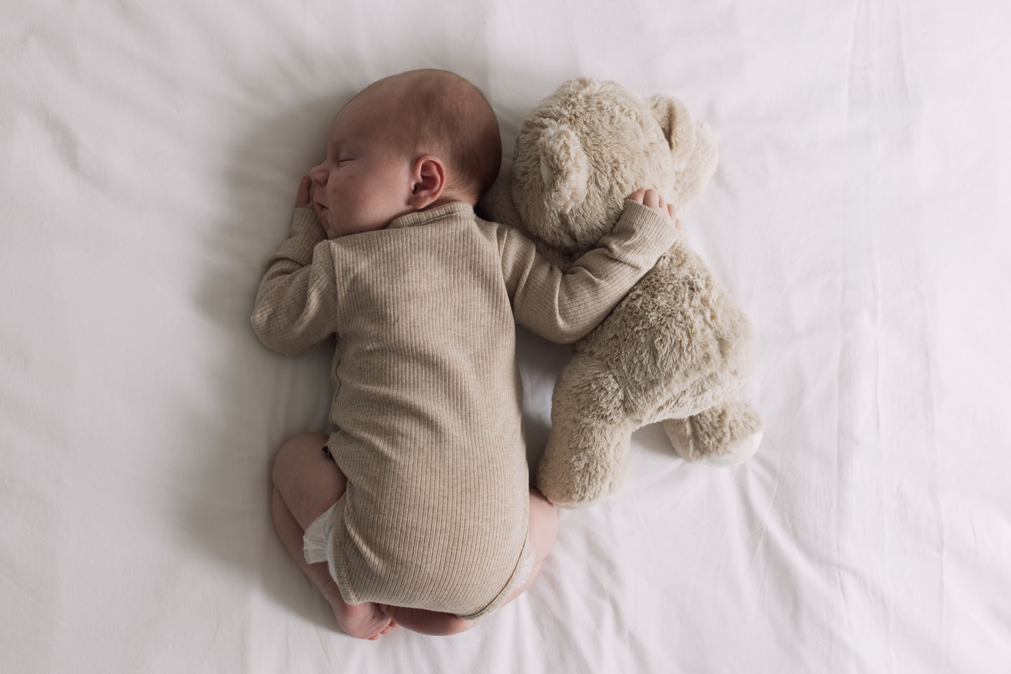 Baby slapen met knuffelbeer tijdens de newbornshoot