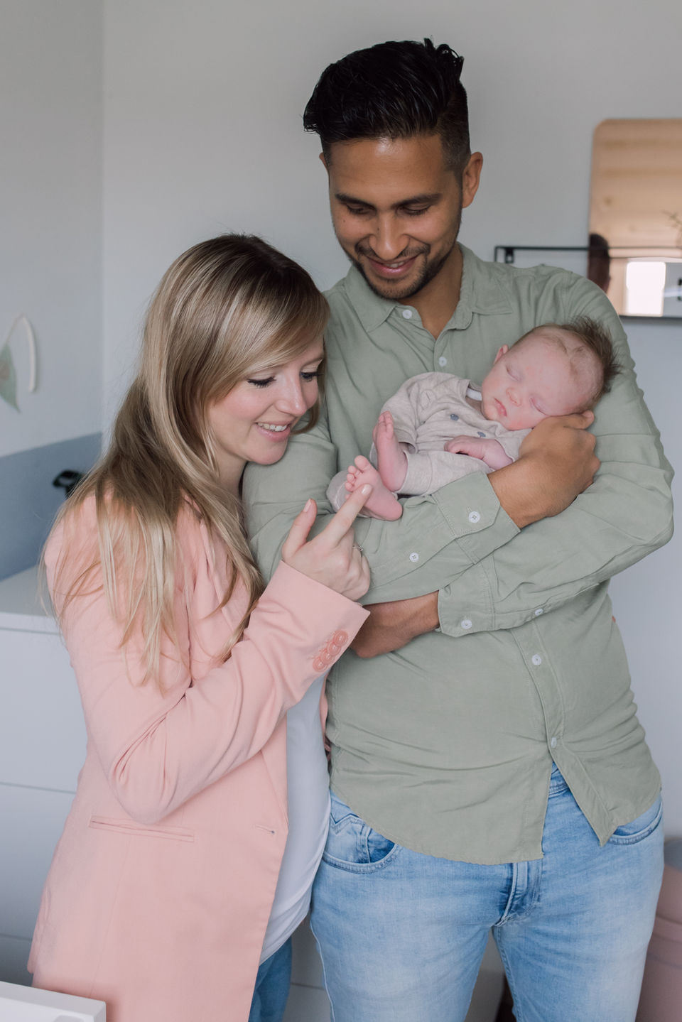 Knuffelen bij papa en mama in de armen tijdens een newbornshoot
