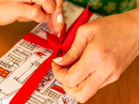 A hand tying a cross-over ribbon bow