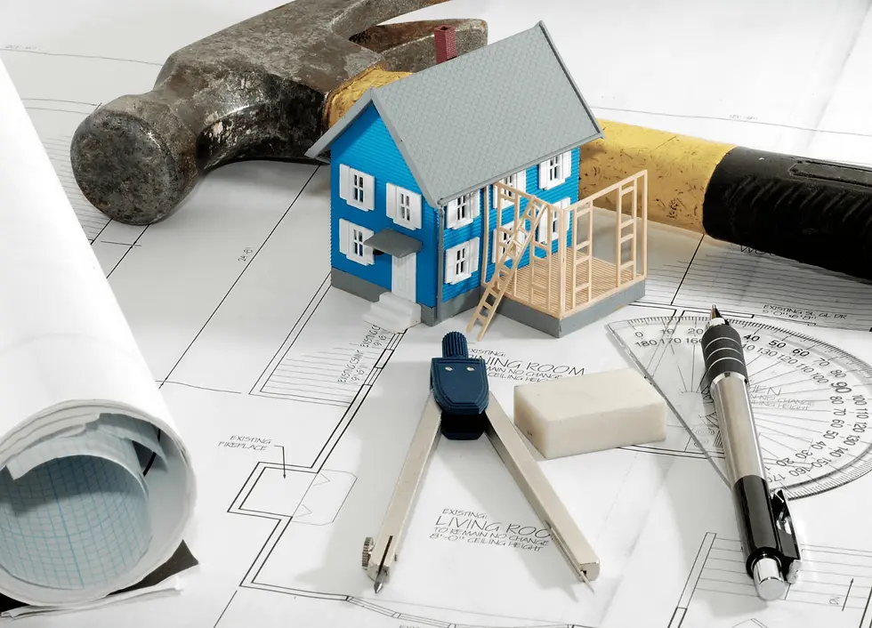 Image showing a house model, hammer and stationary items like pen on a blueprint of a house