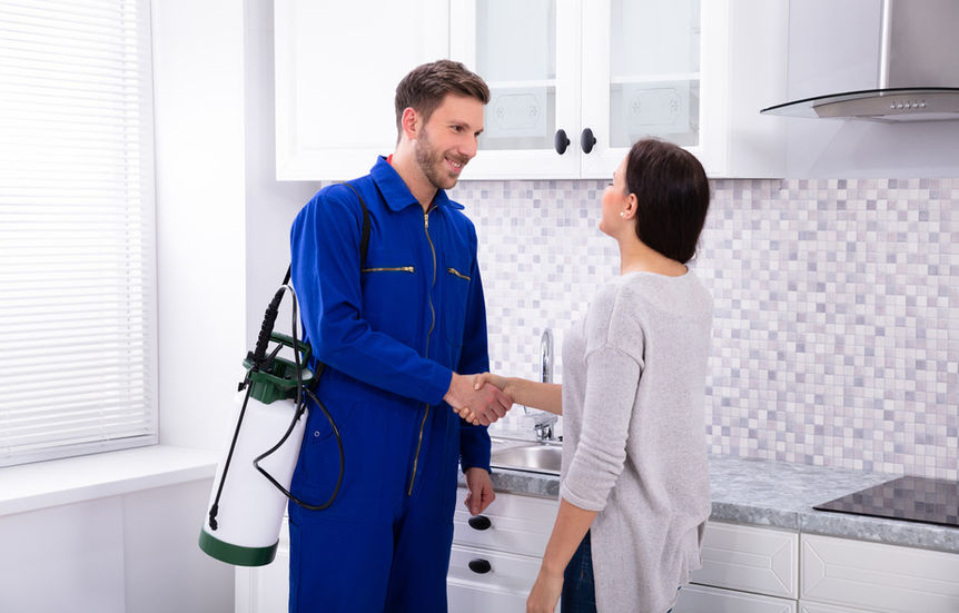 pest control worker shaking hands with a happy customer