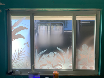 Custom decorative window film with tropical plants and a flying humming bird. Background with a clear frost gradient.