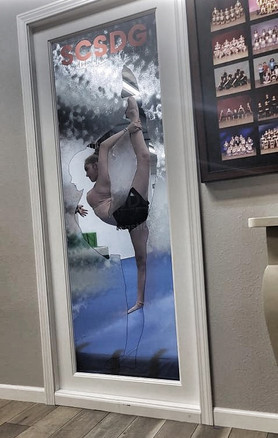 Window design with textured glass look in clear. Creates distortion of image where the texture is applied. Clear area with dancer holding a pose. Colored frost logo on top.