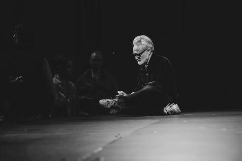 Bradley Whitford seated onstage during a quiet moment at SXSW in a black-and-white photograph.