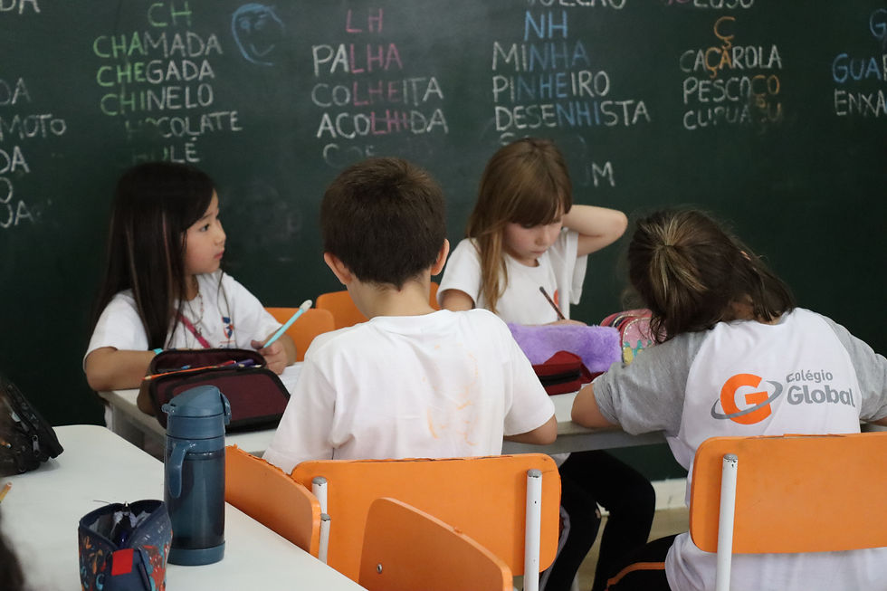 Crianças sentadas à mesa estudando.