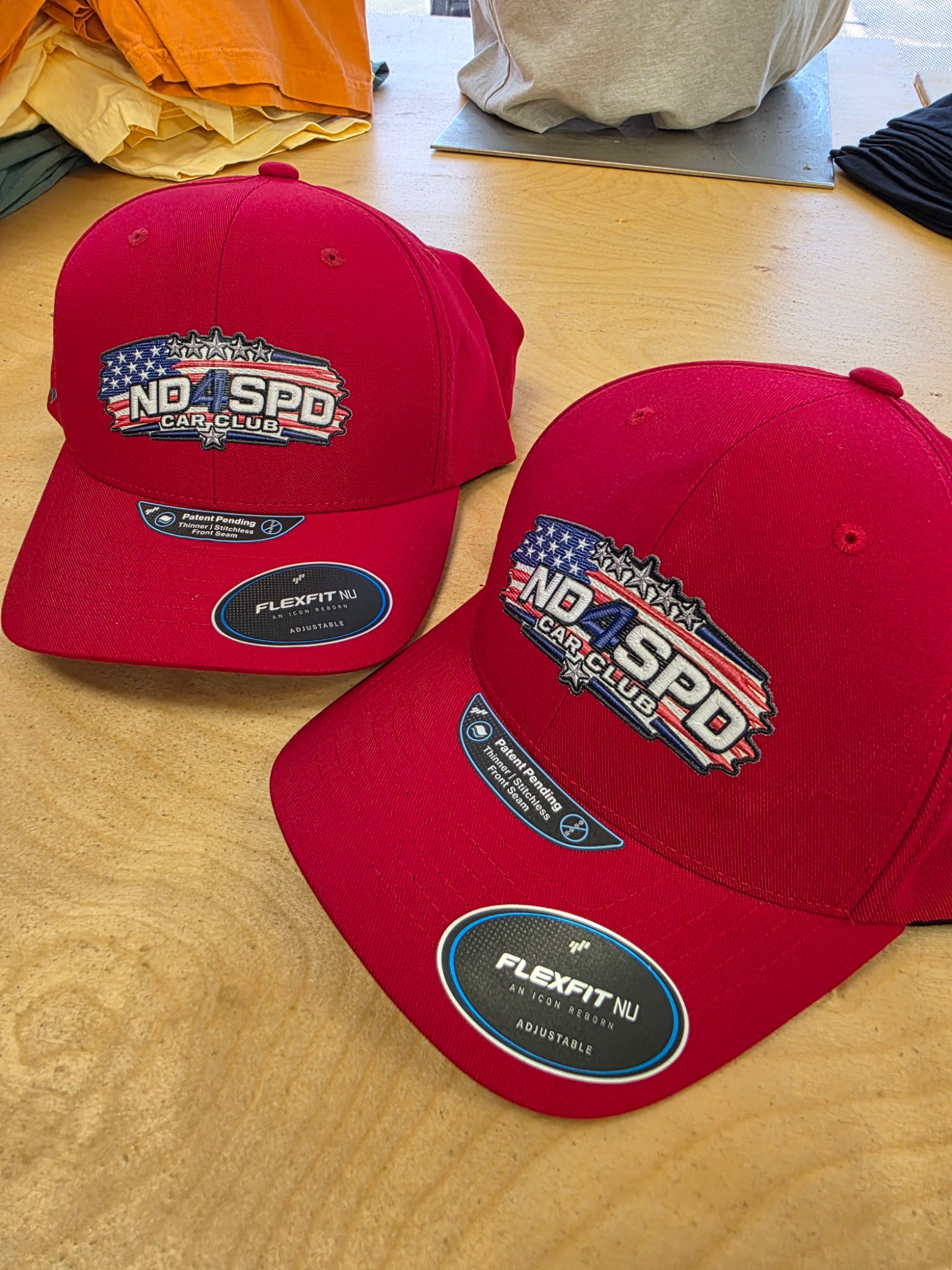 Red ND4SPD custom hats with heat-applied embroidered-look patches