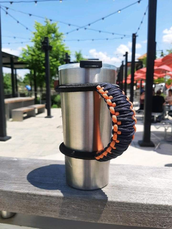 Mug with a paracord handle beside orange beach umbrellas