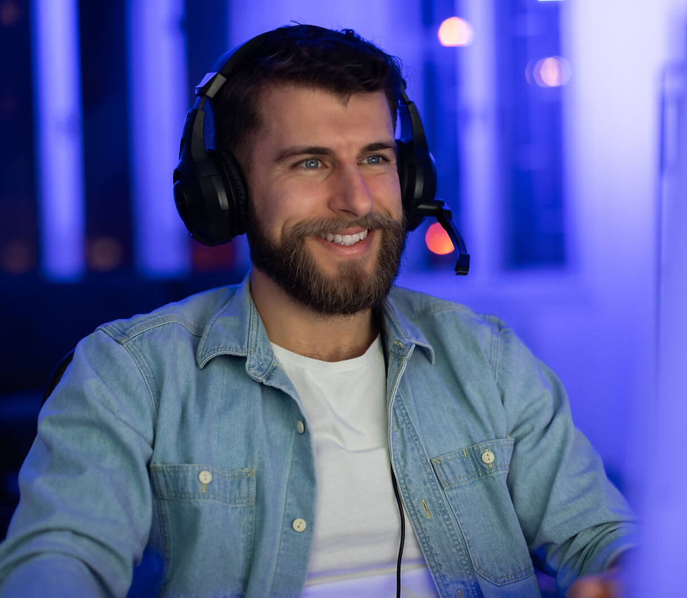 Smiling man wearing headset, looking to the side, blue background.