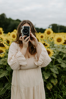 virginia capturing a photo in a sunflower field with her camera