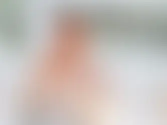 Bride seated at a candle-lit wedding reception table holding a coupe glass, surrounded by soft florals, taper candles, and warm ambient lighting