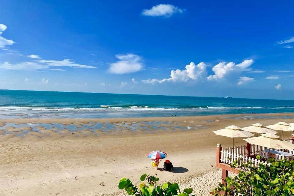 Beach scene with two people relaxing under a colorful umbrella. Clear blue sky, turquoise sea, and sandy shore create a tranquil mood.