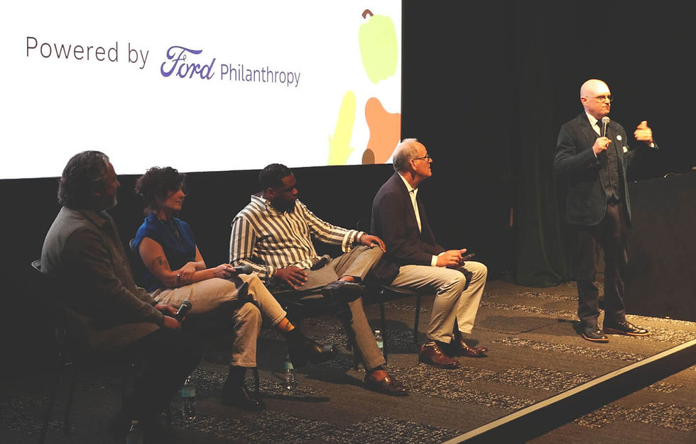 Spence Medford of The Henry Ford addresses the audience as the panel members look on. Photo by Bob Benenson.