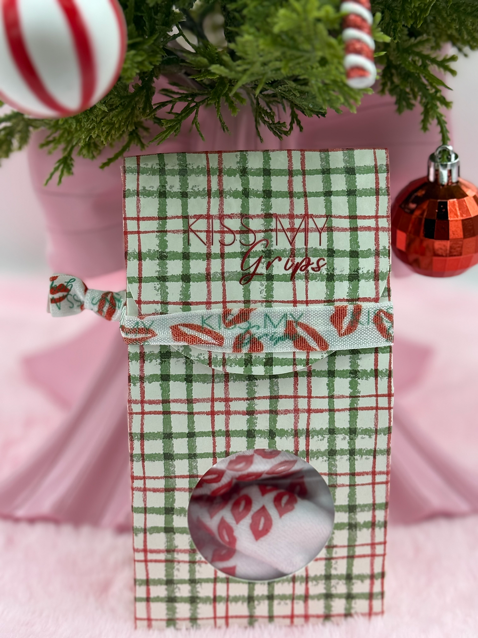 Thumbnail: Holiday gift box containing 'Naughty / Nice' grip socks with festive wrapping and decorations.