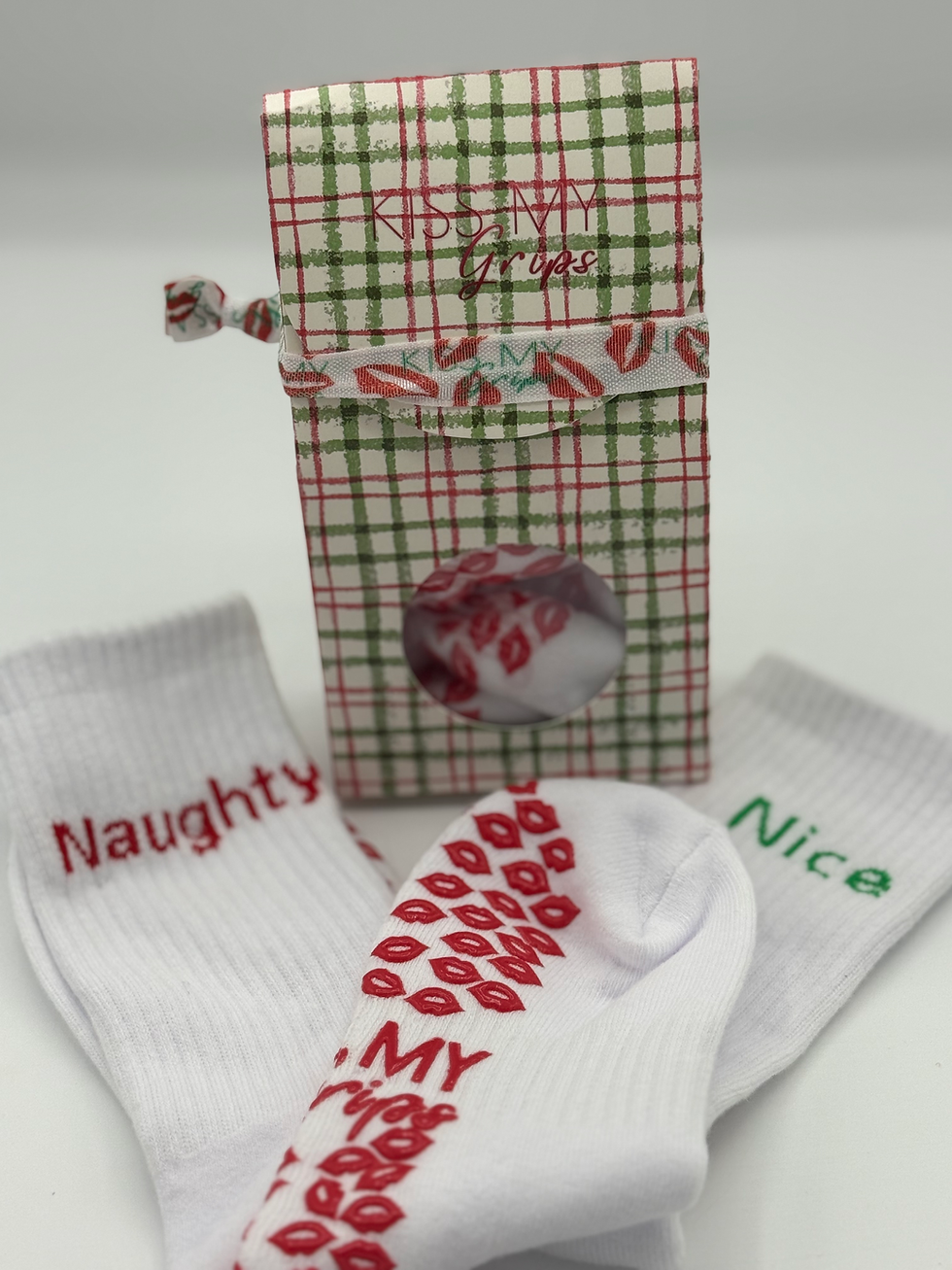 Thumbnail: Packaged 'Naughty / Nice' grip socks displayed with holiday-themed background and gift presentation.