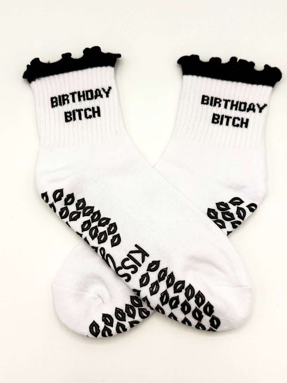 Thumbnail: Angled flat lay of white grip socks with visible grip pattern and printed text along the calf.