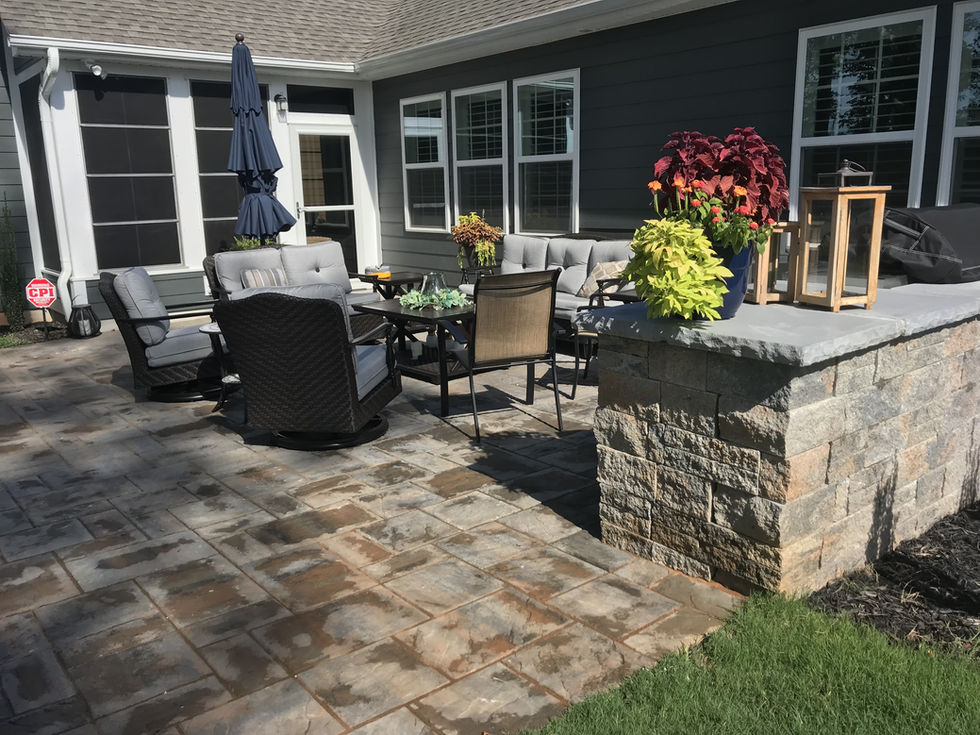 Small patio with stone pavers, outdoor seating, and planters