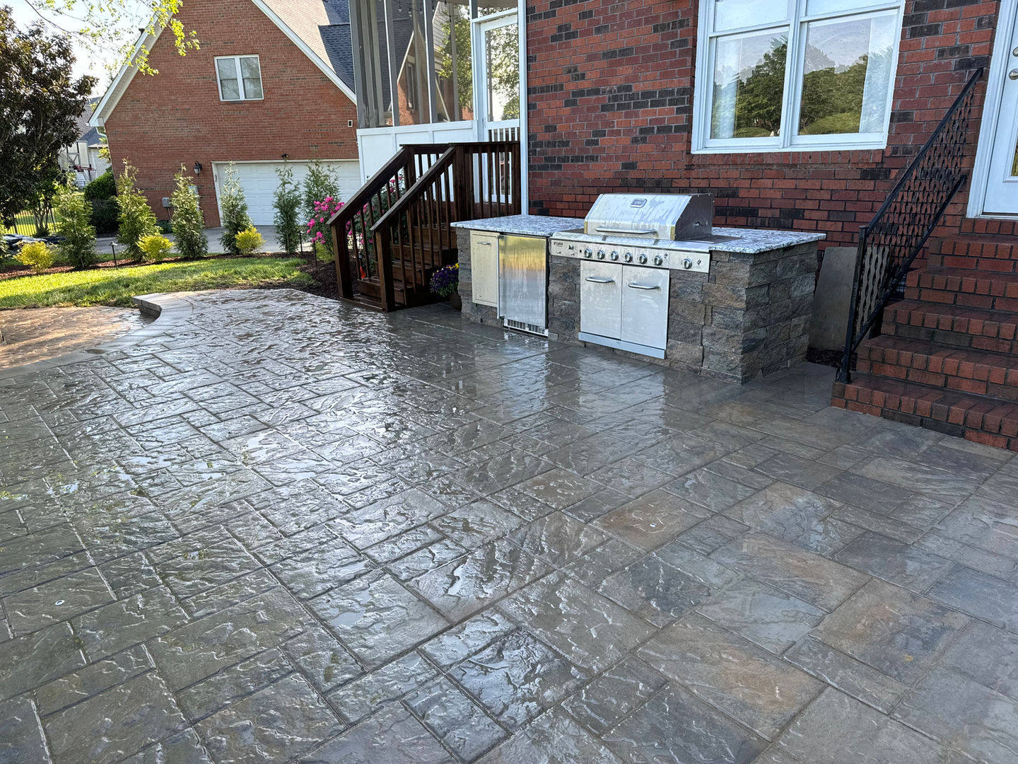 Large patio with stamped concrete and outdoor kitchen grill.