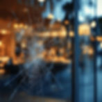 Close-up of a cracked security glass window in South Miami showing visible bullet impact, highlighting the strength of CoolVu ballistic-resistant glazing.