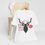 Thumbnail: A christmas inspired t-shirt with a moose wearing headphones and text that reads "It's ok to say ho ho ho"