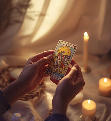 Artwork of two gentle hands holding a tarot card, with soft golden light. The background i