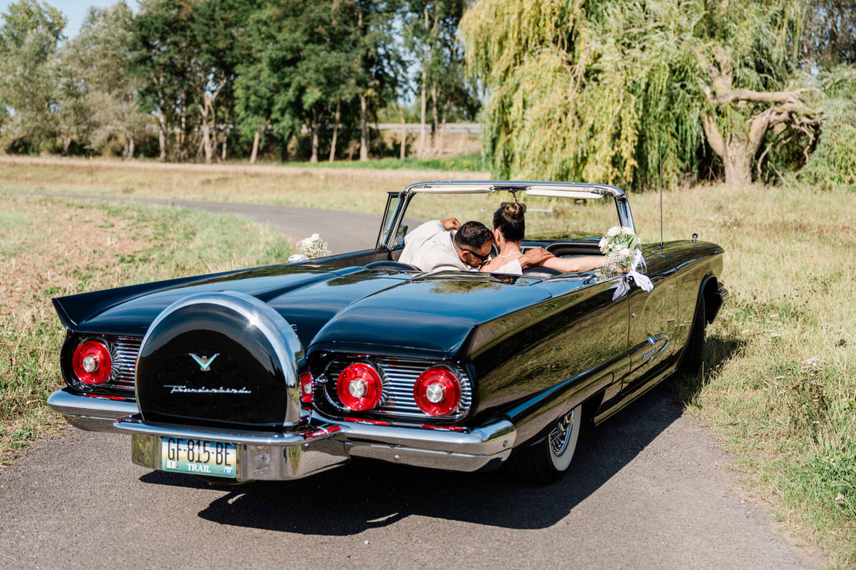 Couple dans une voiture américaine décapotable