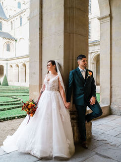 Mariés marchant sous des arcades en pierre, lumière naturelle