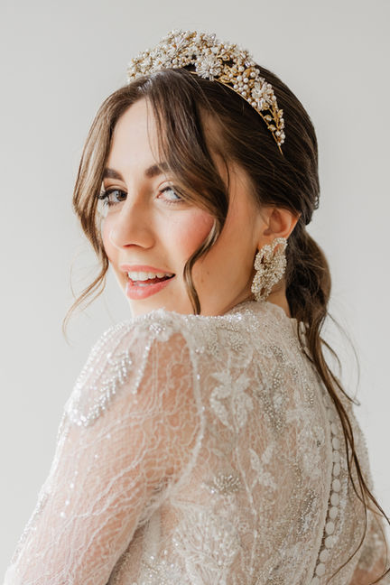 Mariée souriant de profil avec une couronne délicate.