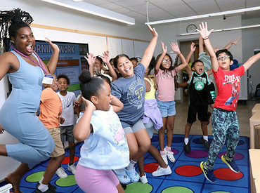 Students and teacher jump with excitement in classroom.