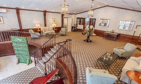 Overhead view of the Essex Club lobby, showing stairs, a grand piano, the champagne display, and surrounding lounge furniture.