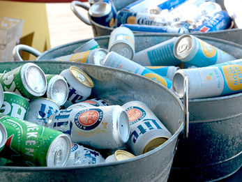 Galvanized metal buckets filled with ice and various cans of beer and hard seltzer.