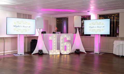Event DJ setup with "Kaylee's Sweet 16" TV monitors flanking a large illuminated "16" sign.