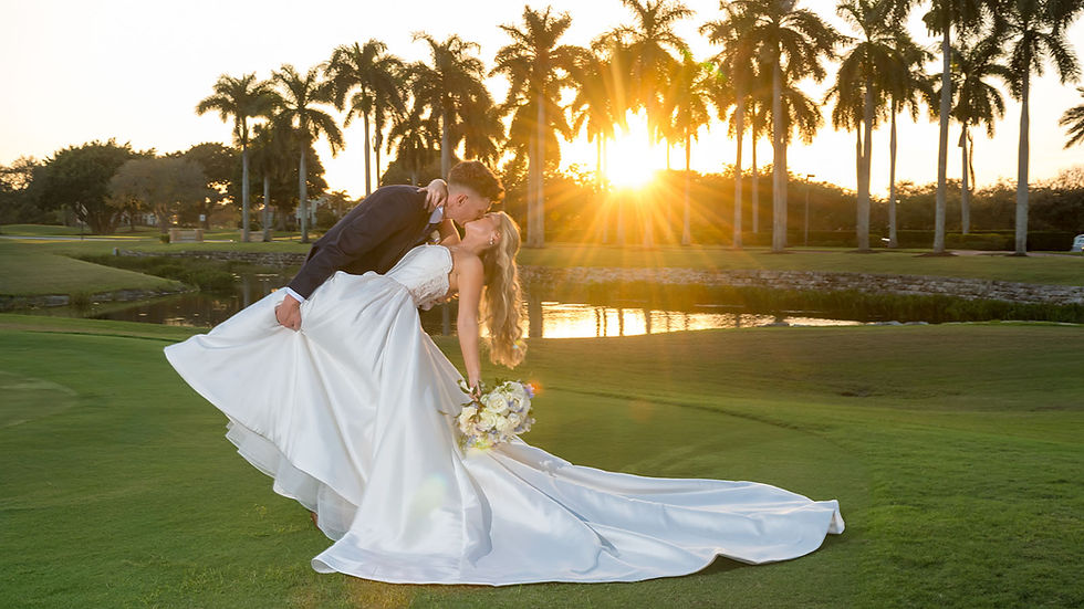 Bride and groom kiss on the golf course during sunset.
