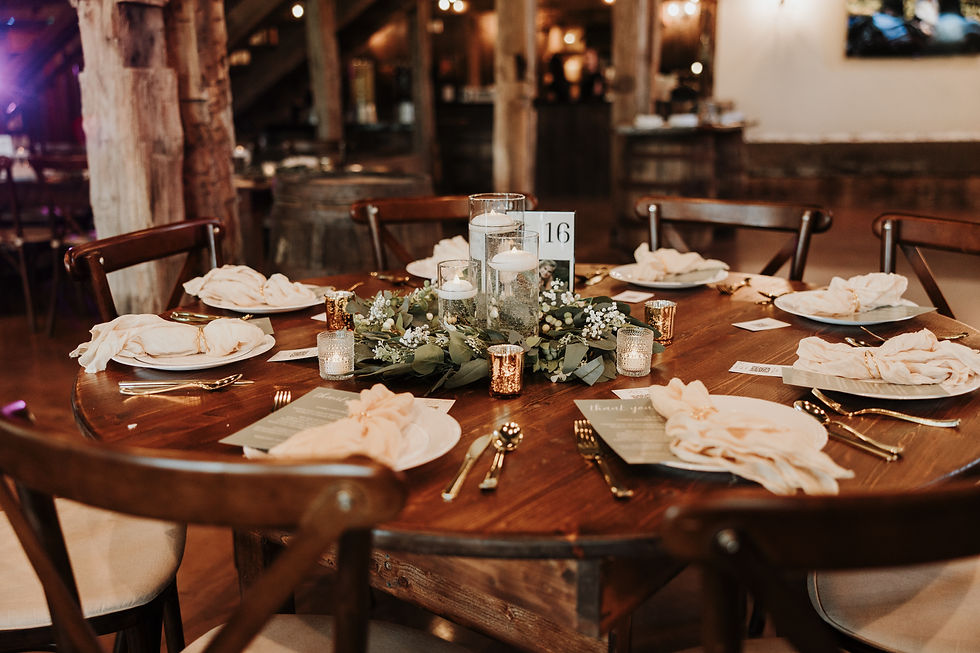 Grove City, OH Wedding Venue Rustic reception table 16 set with candles, greenery, folded napkins, and place settings in a warm barn venue.