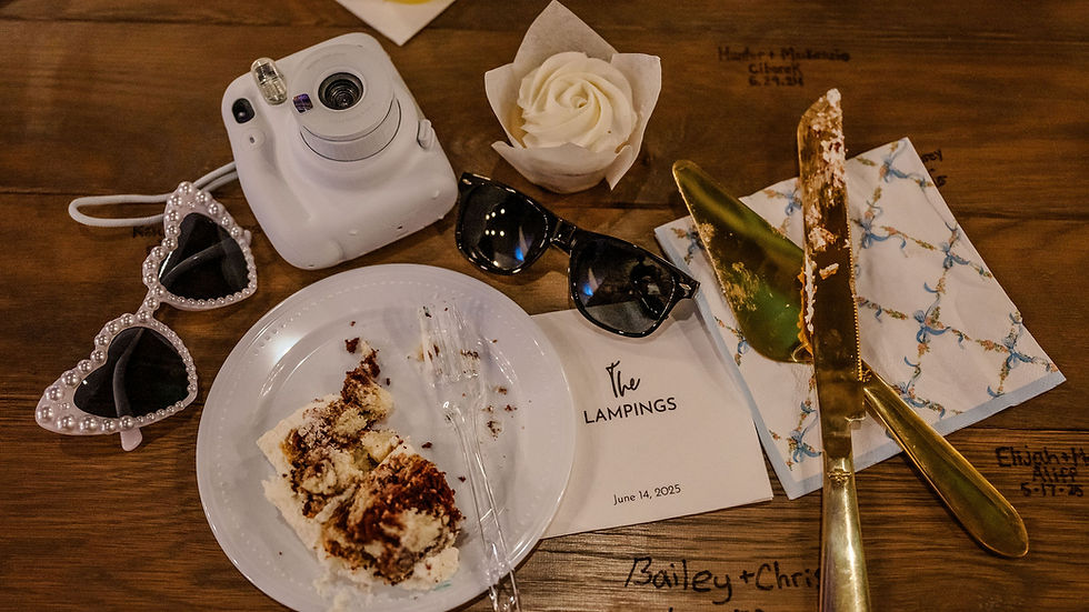 Columbus Wedding Venue near me. Cake remnants on a plate with heart sunglasses, a camera, a cupcake, and a card reading "The Lampings, June 14, 2025" on a wooden table.