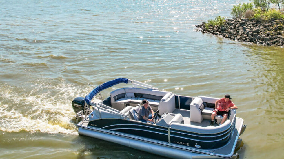 Ohio Wedding Venue. A blue pontoon boat with two people glides on a lake under a clear sky, near a rocky shore. The boat has "Harris" on its side.