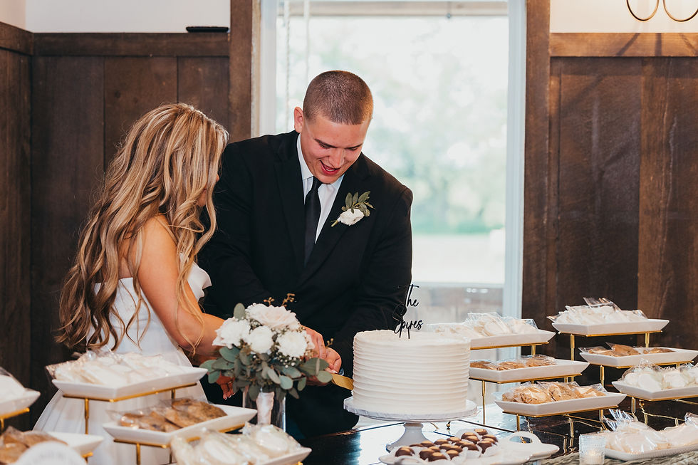 Grove City, OH Wedding Venue Bride and groom in a wood-paneled room cut a white wedding cake surrounded by dessert trays, smiling amid a warm, celebratory mood