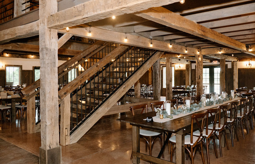 Rustic elegance with wood tables and cross back chairs at rustic Ohio barn venue