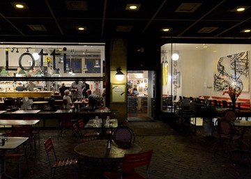 Restaurant Lotti in der Nähe der Uraniastrasse mitten in Zürich. Nachaufnahme mit Blick ins beleuchtete Lokal. Im Lotti gibt es Mittagessen, Abendessen, Kaffee, Wein und Fleisch vom Grill bzw. BBQ.