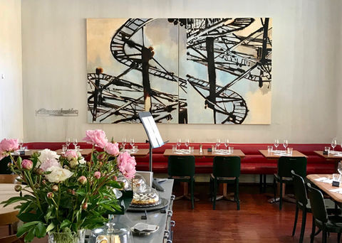 Restaurant Lotti in der Nähe des Hauptbahnhof Zürich. Innenansicht des Lokals mit Bild von Uwe Wittwer im Hintergrund. Vorne die Kuchentheke. Im Lotti gibt es Mitagessen, Abendessen, Kaffee, Wein und Fleisch vom Grill bzw. BBQ