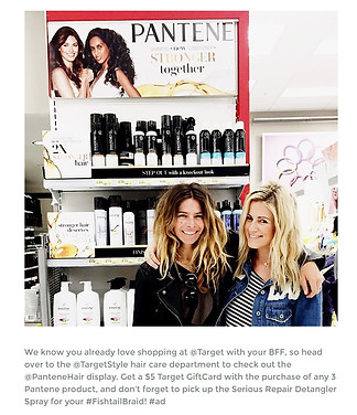 Two women smiling in front a pantene stall